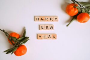 Welkom bij Acupunctuur Aukje in Someren! 3 Happy New Year message with Scrabble tiles and fresh mandarins for festive decor.